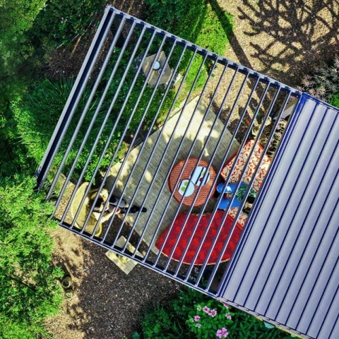 widok z góry na pergolę wolnostojącą MIRADOR Solid 80 3 x 5 m antracyt na tarasie z meblami ogrodowymi i systemem podświetlenia LED zapewniającym komfort użytkowania